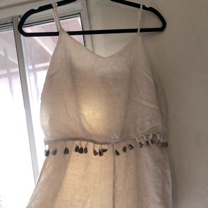 White linen romper with colorful tassel trim